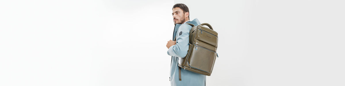 Man wearing an olive green leather Piquadro laptop backpack