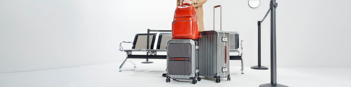 Piquadro leather backpack attached to a trolley in an airport waiting area